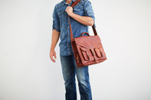 a man standing holding a messenger bag 