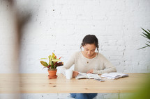 woman sitting at a desk with a Bible reading 