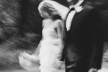 blurry image of a bride and groom walking holding hands
