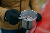 a man cooking oatmeal outdoors 