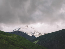 Snowy and cloudy peak in summer