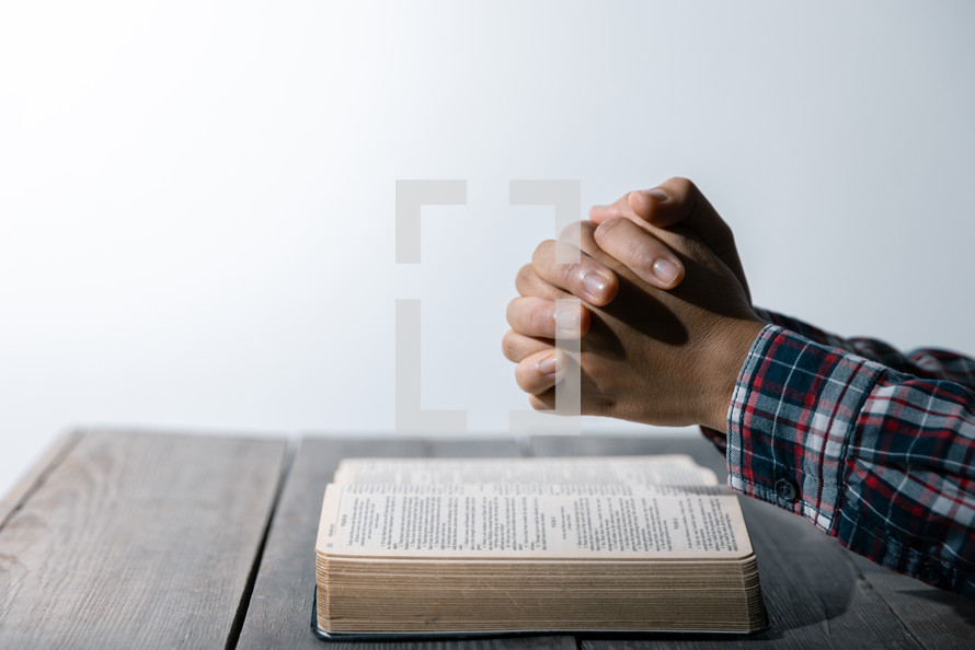 White background and praying hands and Bible