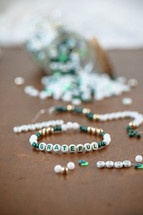 Jar of green, white, and gold beads with word - grateful
