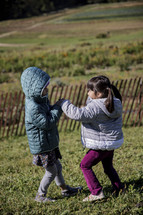 Little girls creating playing on a hill in the fall