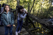 Little girls walking on a wood bridge