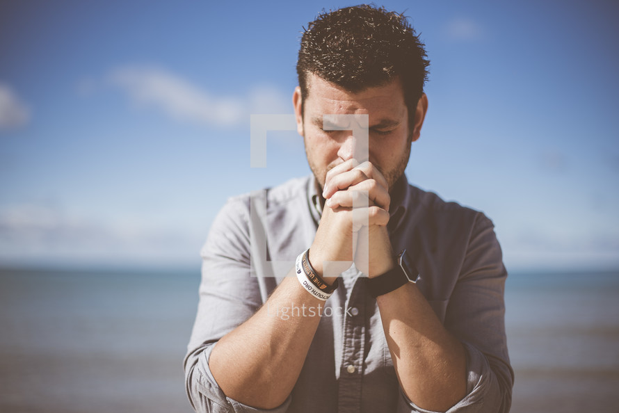 a man praying on a beach 