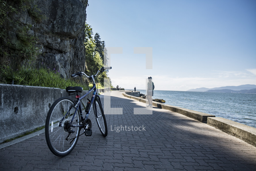 bicycle on a brick sidewalk along a shore 