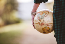a woman holding a globe 