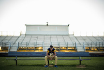 young man in his football jersey praying 