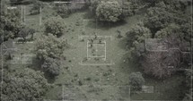 Surveillance drone view of soldiers walking through a forest with hud graphics