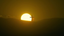 Silhouette of Christian cross in the mountains at sunset timelapse