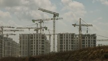 Large construction site with many cranes working over buildings