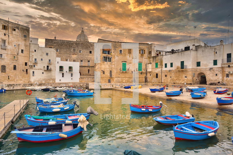 Fishing boats in Monipoli city bay with cloudy sky background, southern Italy, Europe