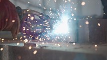 Slow motion of a welder welding construction steel frames in a construction facility