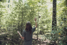 woman waving in a forest 