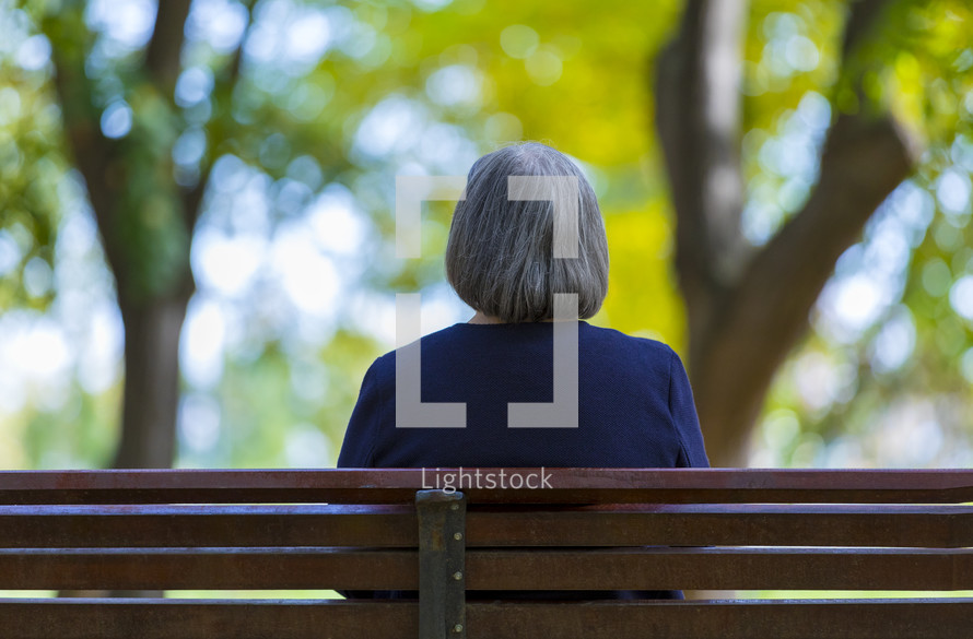 a woman sitting alone on a bench 