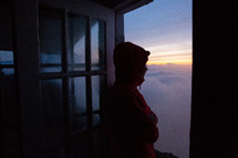 a woman looking out a window above the clouds at high rock lookout 