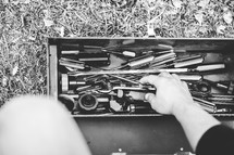 a man sorting through a toolbox 