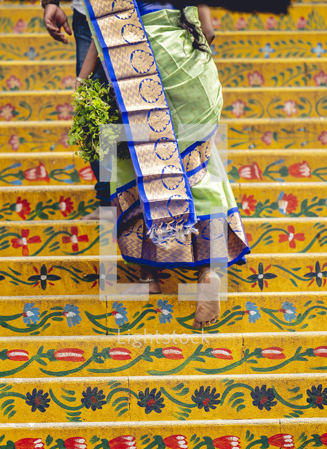 Woman walking up the steps of the Varaha Lakshmi Narasimha Hindu temple in India.