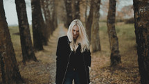 a blonde woman standing outdoors in fall 