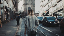 woman walking on a city sidewalk 