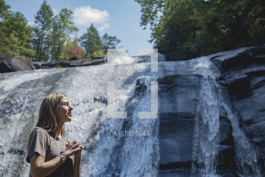 praying in front of a waterfall 