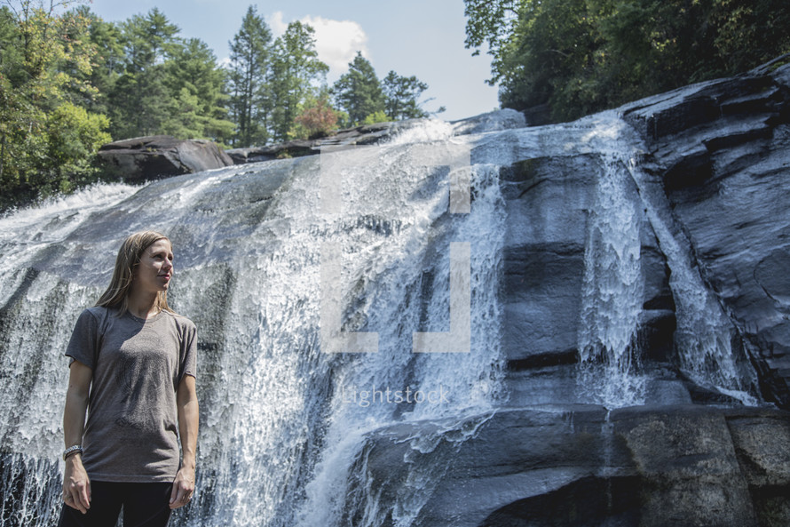 woman standing in front of a waterfall in Asheville, NC