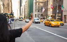 tourist hailing a taxi cab in NYC