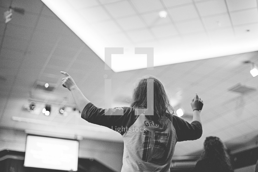 young woman inspired and standing up at a worship service 