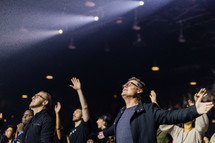people singing worship music and praying at a conference 