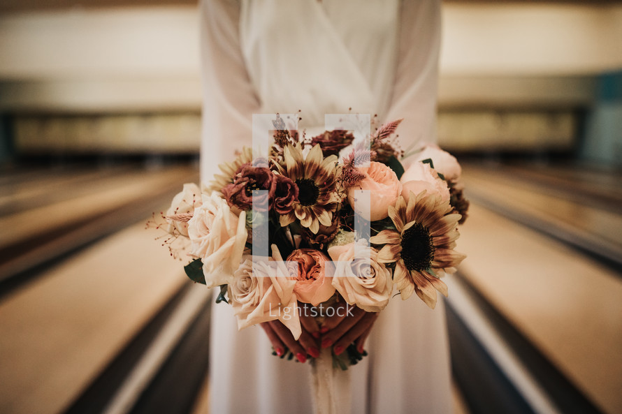 bride standing in a bowling alley 