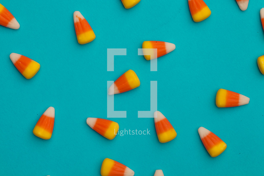 scattered candy corns on a blue background 