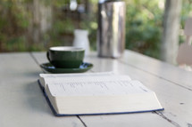 coffee and open Bible on a wood table 