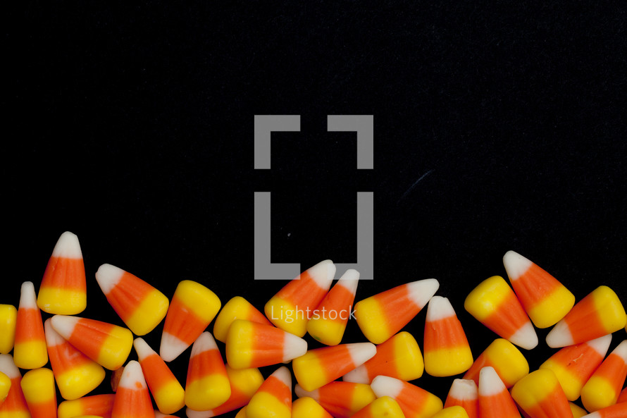 border of candy corn on a black background 
