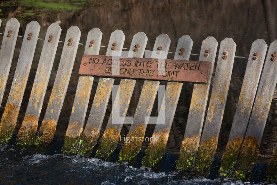 No access signage on a fence by water