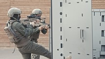 Soldiers training in close quarters combat with automatic rifles