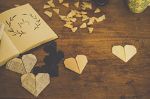 Paper hearts on a wooden table.