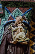 statue of a Saint holding a baby in France 