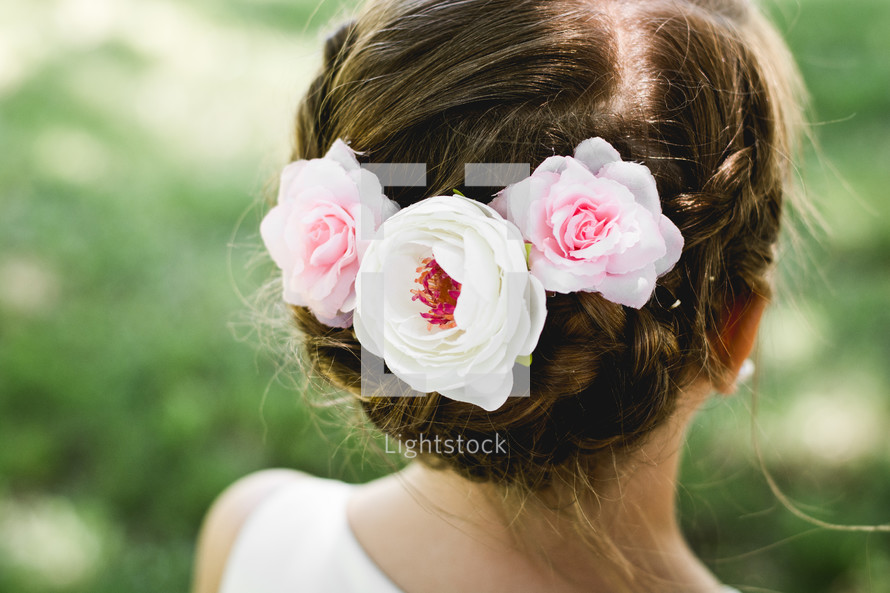 A little girl with flowers in her hair.