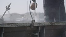 Construction workers cleaning steel concrete molds