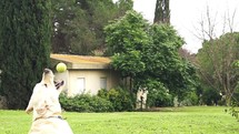 Super slow motion of a white dog catching a tennis ball.