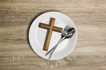 cross and silverware on a plate 