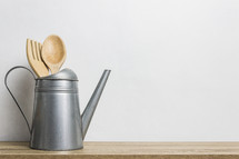 wooden kitchen utensils in a watering can 