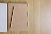 notebook, and pencil on a wood table 