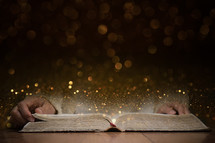 open Bible and sparkling bokeh lights 