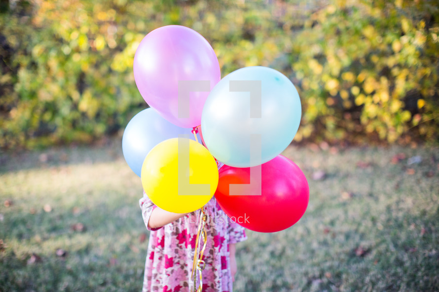 a child holding balloons 