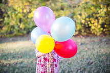 a child holding balloons 