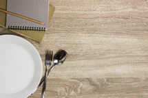 empty plate, silverware, and journals 