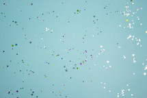 Turquoise background with colorful heart confetti