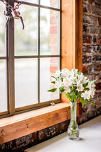 vase of flowers in front of a window 